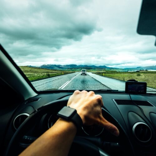 a person wearing a smart watch driving on a rainy road