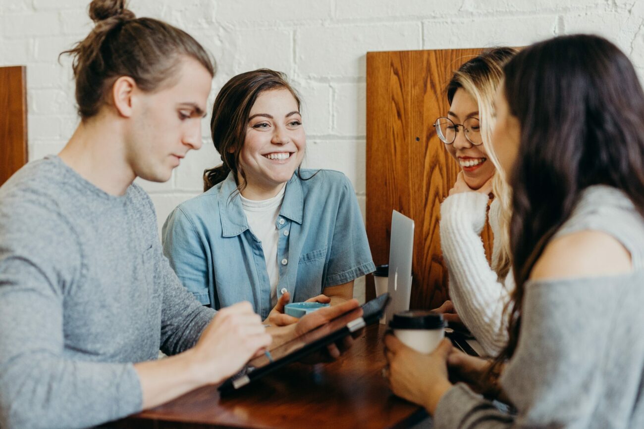 4 people talking in a circle smiling