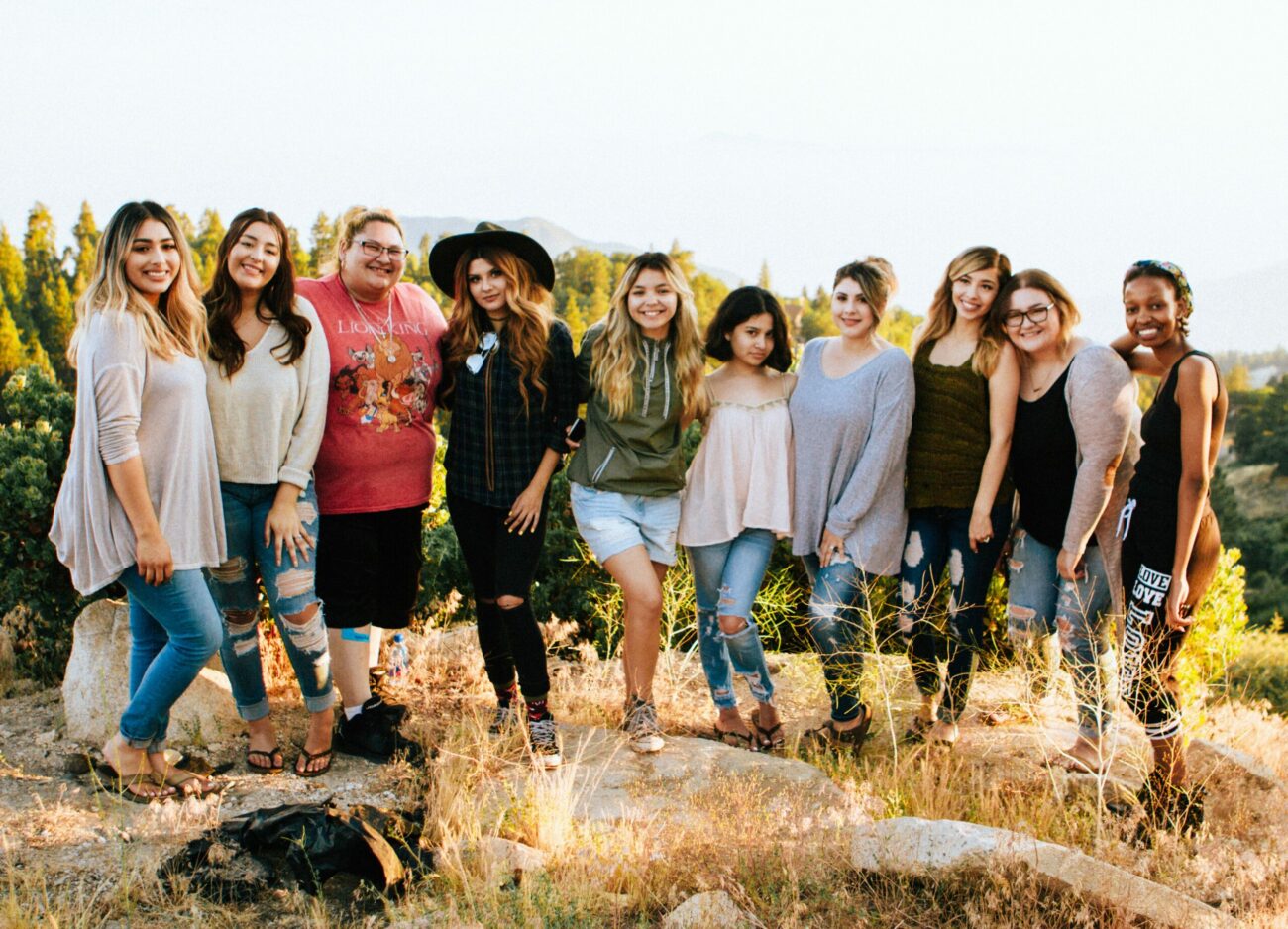 group of young people standing in a field smiling