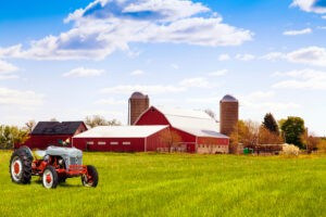 Farm Insurance coverage for a traditional American red farm with tractor in Colorado, protecting crops, equipment, and property.