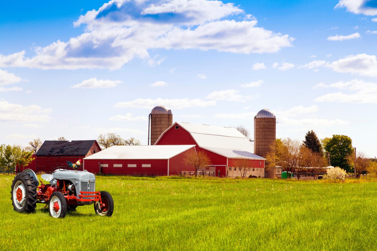 Farm Insurance coverage for a traditional American red farm with tractor in Colorado, protecting crops, equipment, and property.