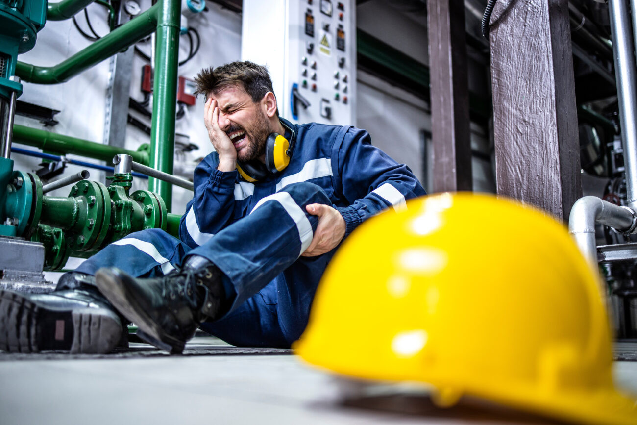 Factory worker experiencing a workplace injury while on the job, highlighting the importance of Work Comp Insurance for employee protection.