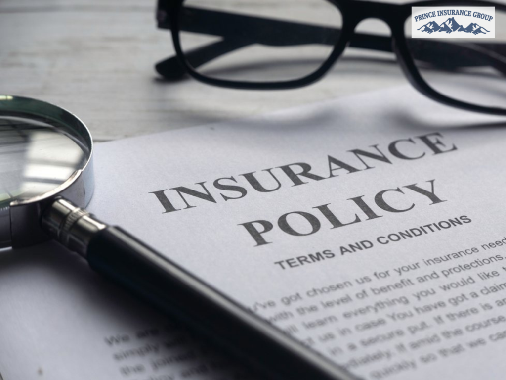Business Insurance policy document with a magnifying glass and eyeglasses on a desk, symbolizing the importance of reviewing and updating insurance coverage regularly.